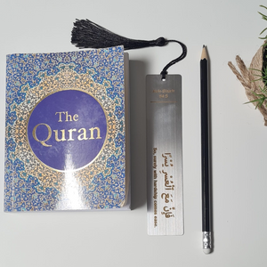Personalised engraved metal bookmark with Islamic quote from the Quran next to an English translation of the Quran and a black pencil.